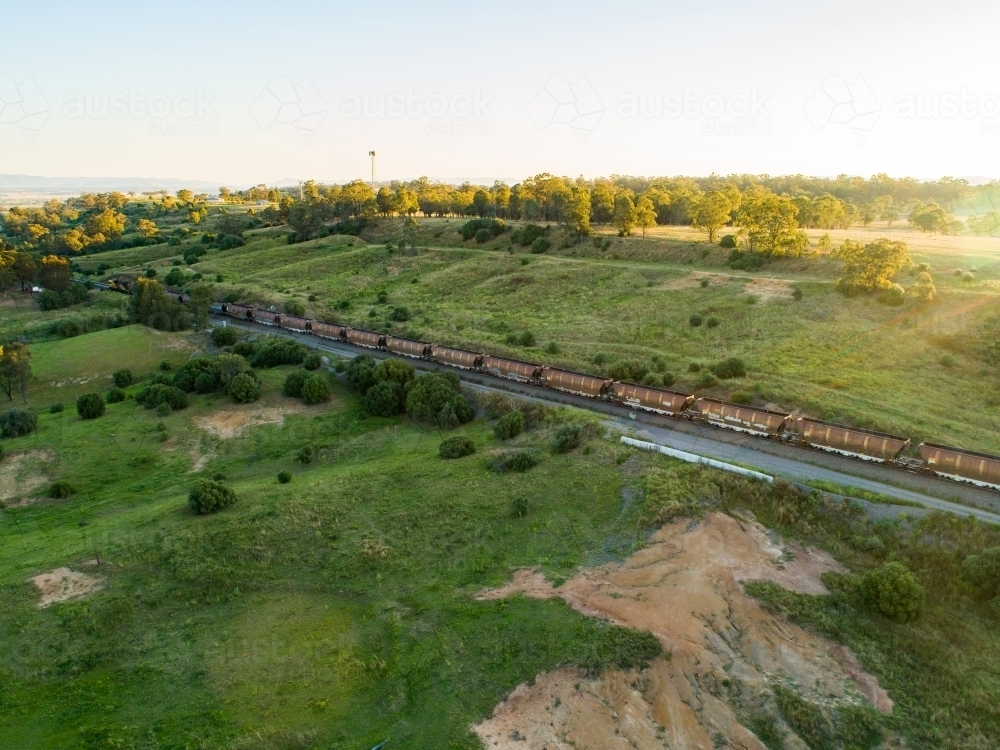 Coal train seen from drone on railway track through green landscape in Hunter Valley - Australian Stock Image