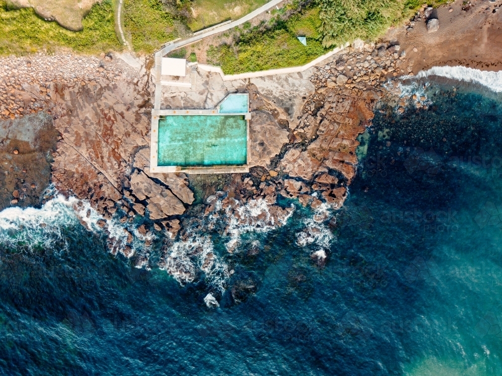 Coalcliff sits on a cracking crumbling rockshelf and its pools are fed by the ocean tides - Australian Stock Image