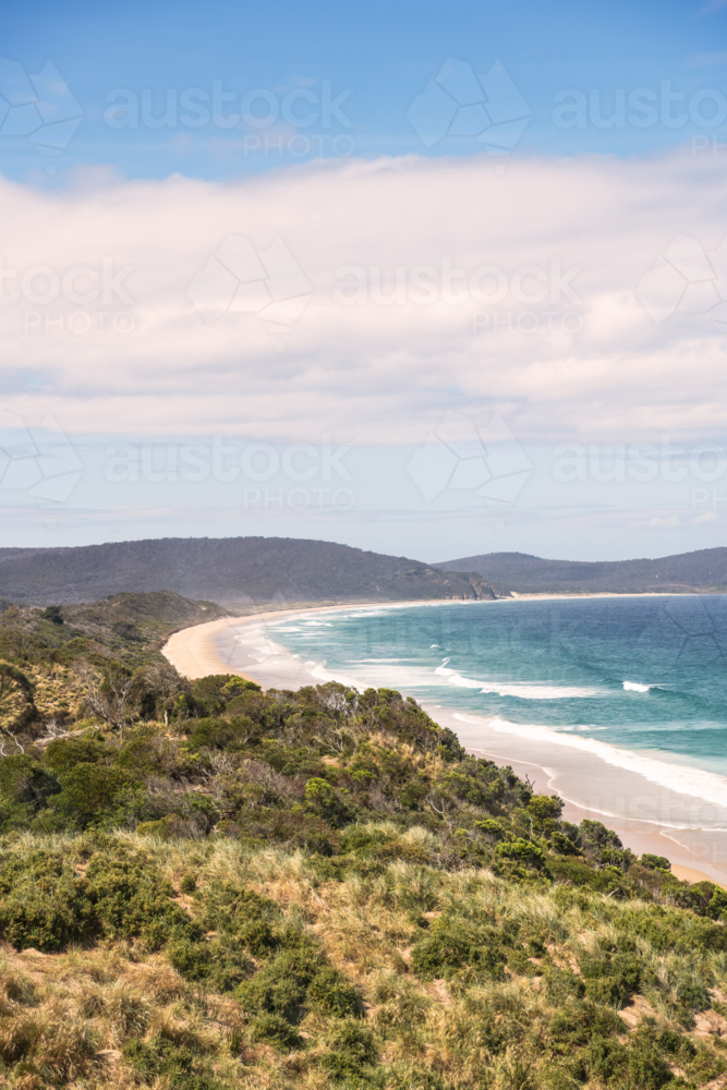 Coastal long shot of white sandy beach with surf - Australian Stock Image