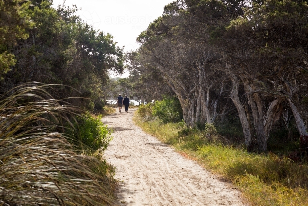 Coastal path with couple walking in the distance - Australian Stock Image