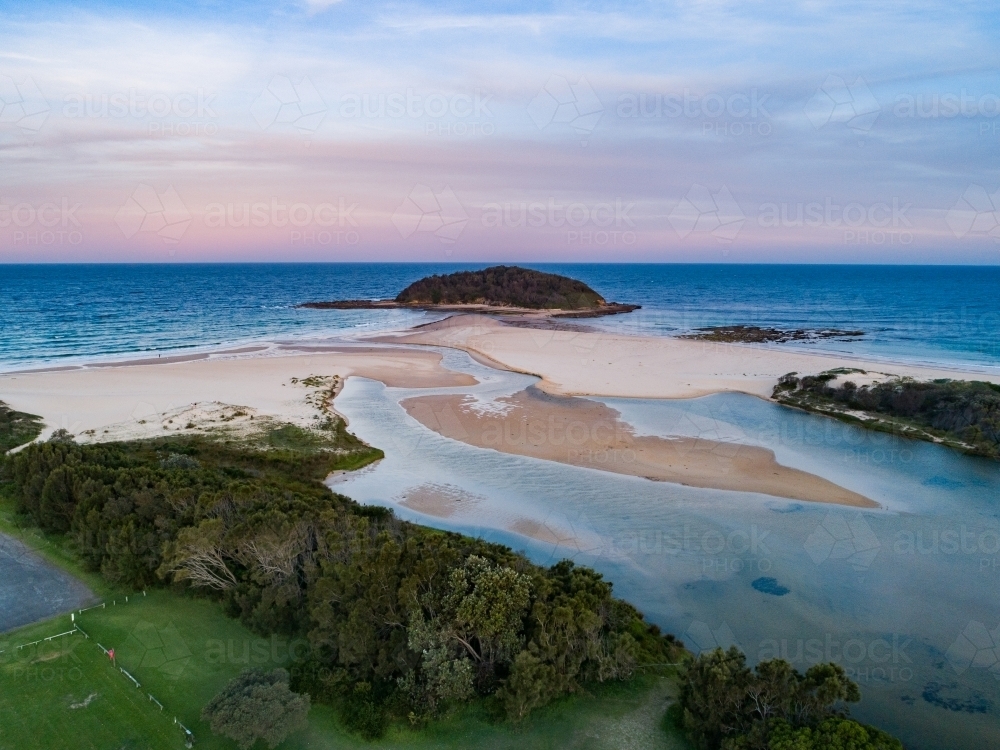 Coastal scene at dusk forest running down to empty sandy beach - Australian Stock Image