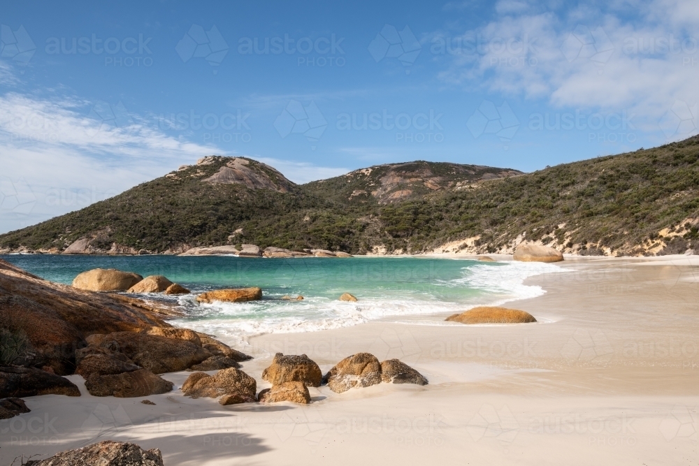 Coastal shot of beach with large rocks on sandy beach - Australian Stock Image