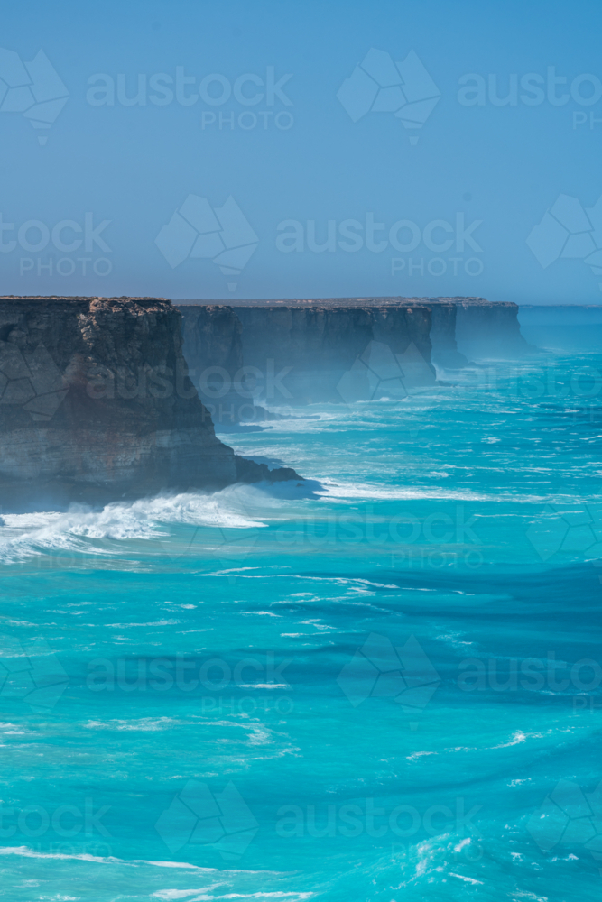 Coastal vista of towering, rugged cliffs in an open sea. - Australian Stock Image
