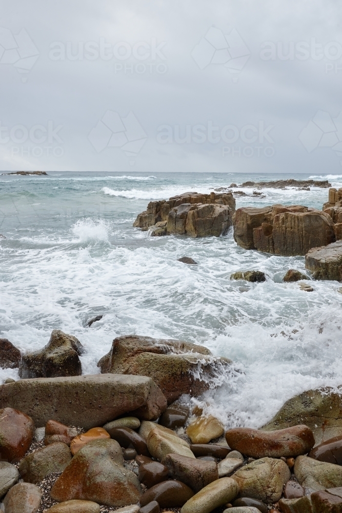 Coastal waves and rocks on overcast day - Australian Stock Image