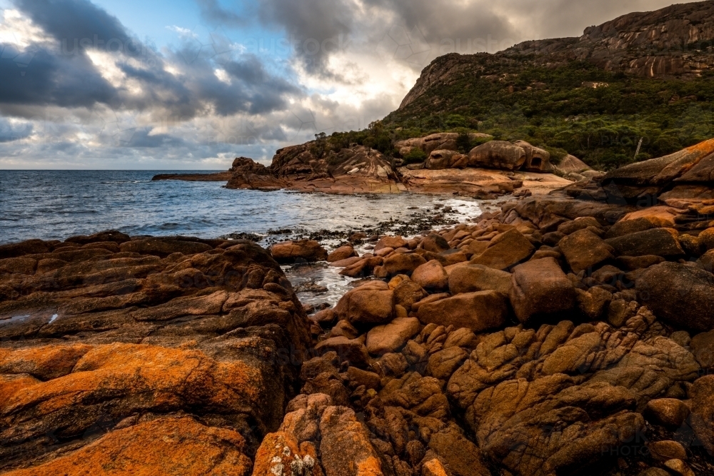 Coastline with red rocks and cloudy sky - Australian Stock Image