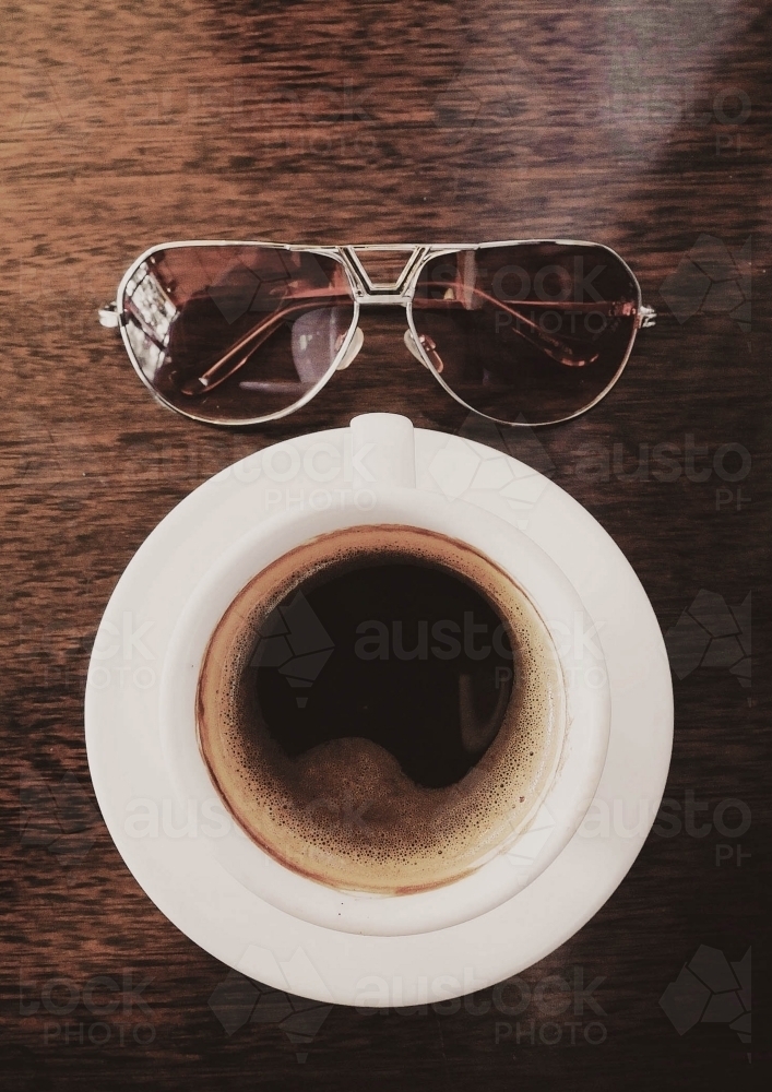Coffee and sunglasses on table - Australian Stock Image