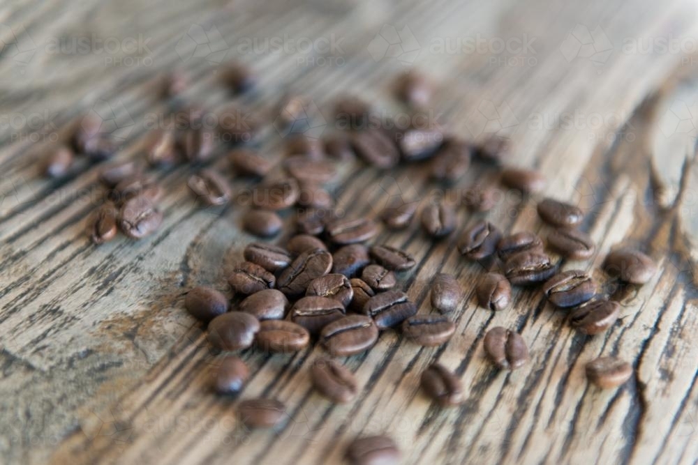 Coffee beans with wood grain table background - Australian Stock Image