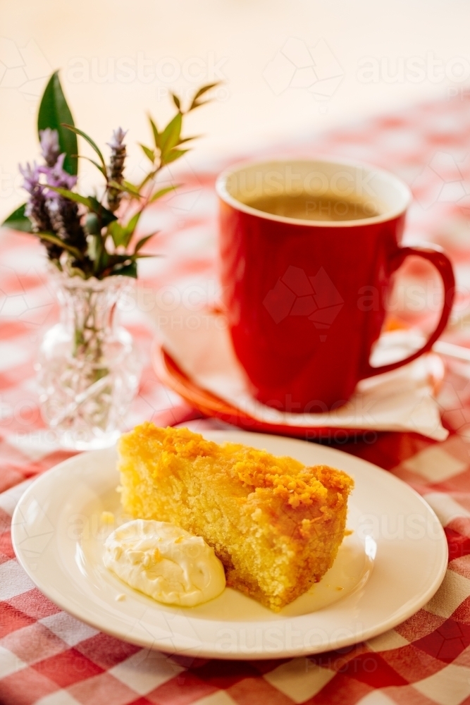 Coffee cake and flowers on checkered table cloth - Australian Stock Image