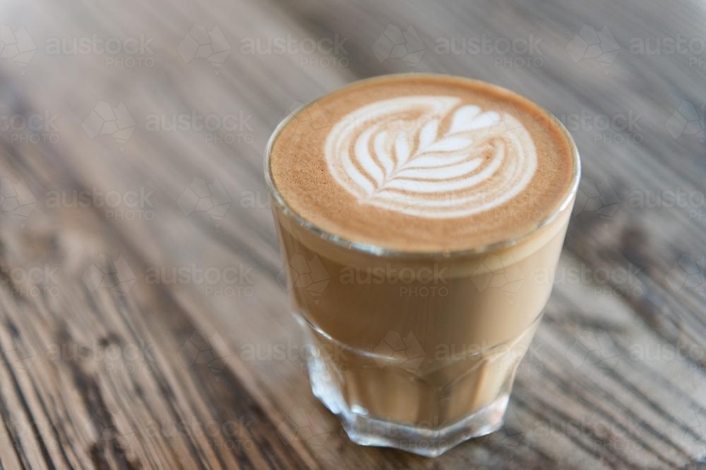 Coffee in a glass on a wooden table - Australian Stock Image
