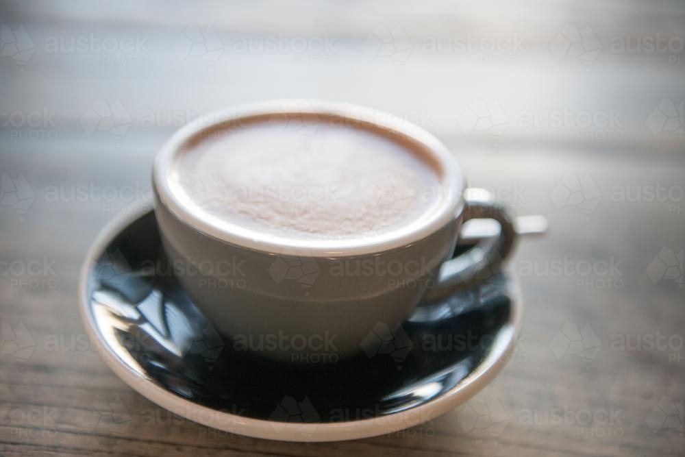 Coffee in a small mug on a wooden table - Australian Stock Image