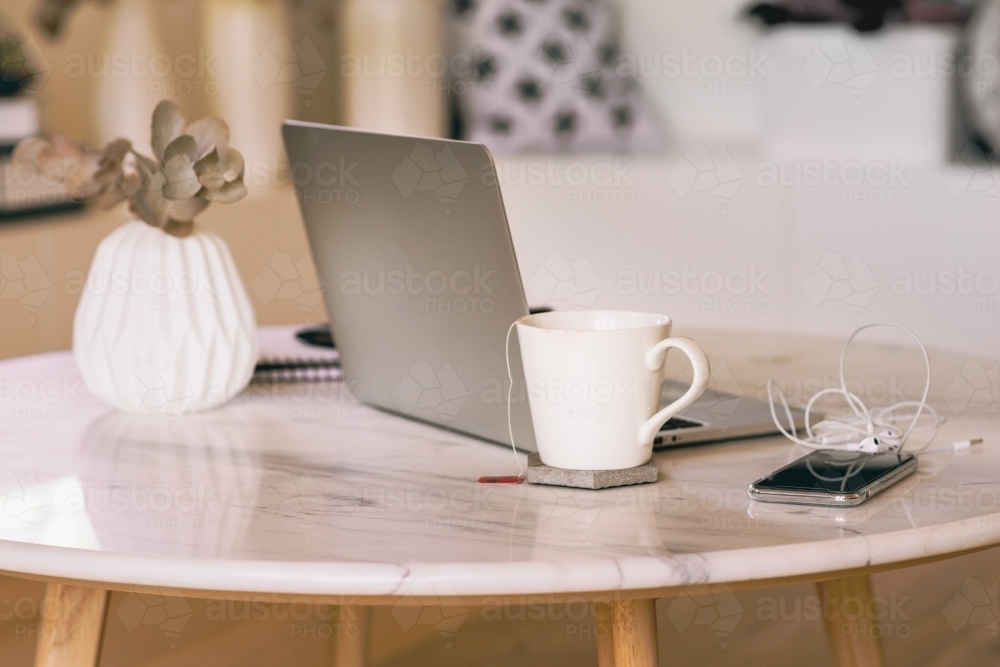 coffee table with laptop, phone and tea - Australian Stock Image