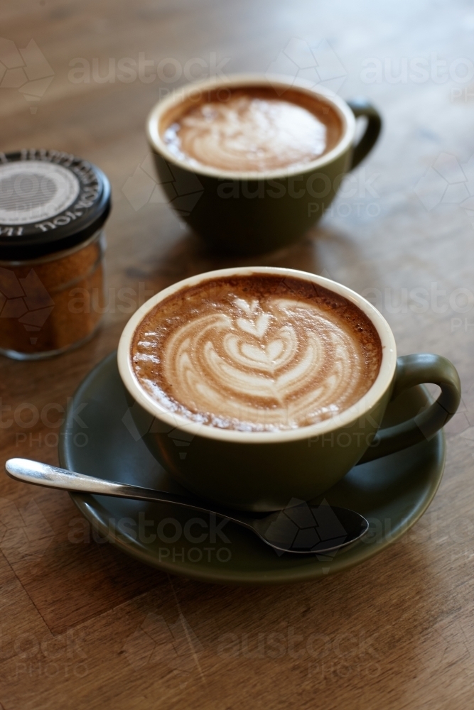 Coffee with froth decoration served on table - Australian Stock Image