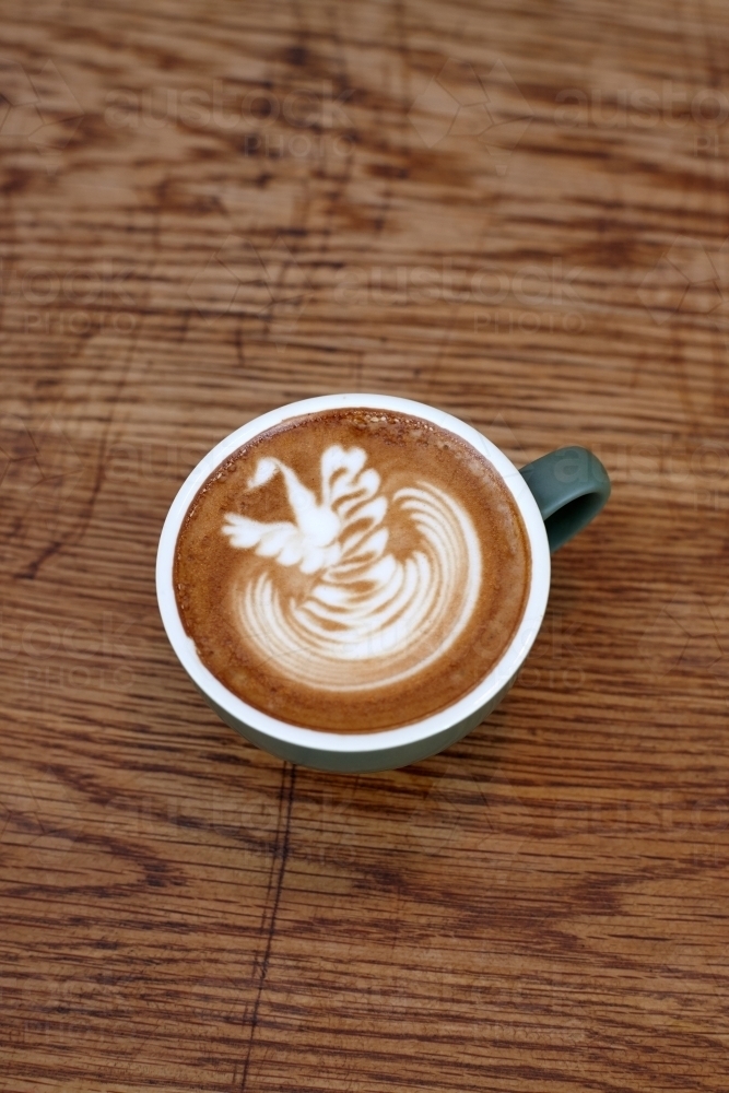Coffee with froth decoration served on table - Australian Stock Image