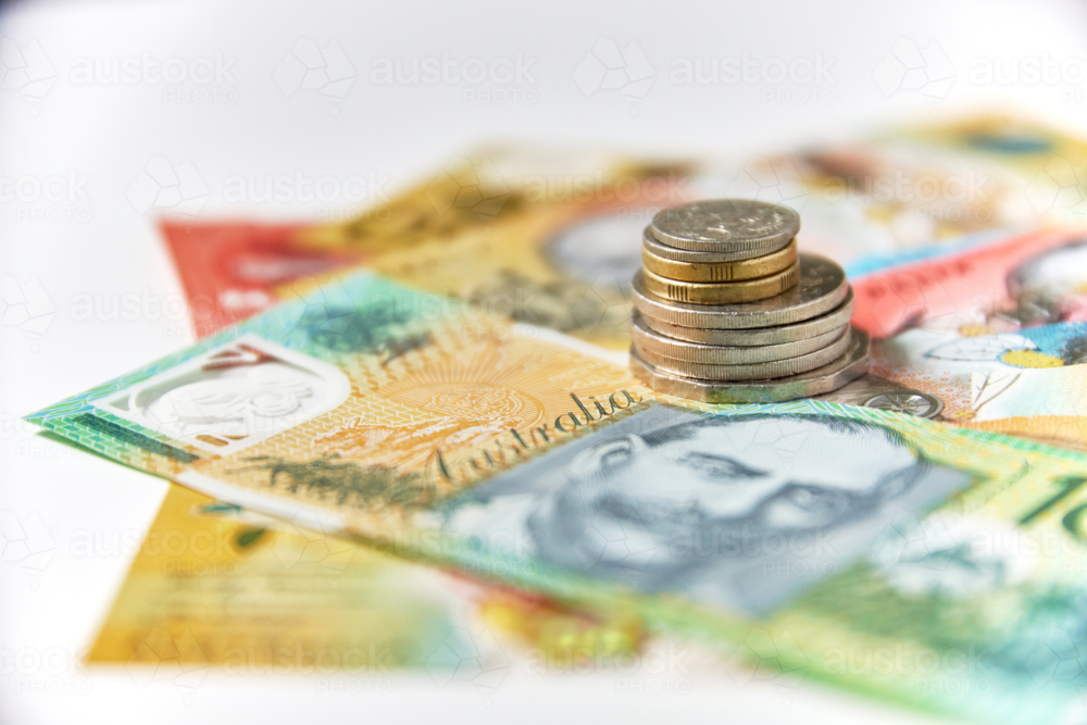 Collection of Australian banknotes and coins scattered on a flat surface - Australian Stock Image
