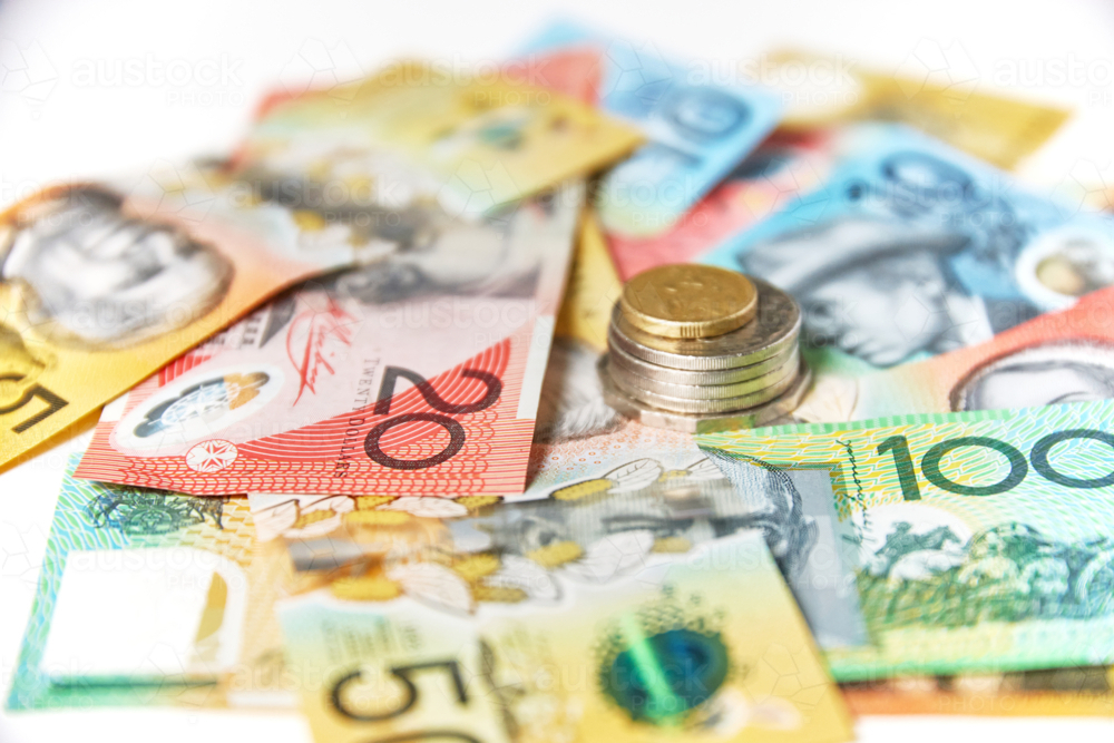 Collection of Australian banknotes with coins stack on a flat surface - Australian Stock Image