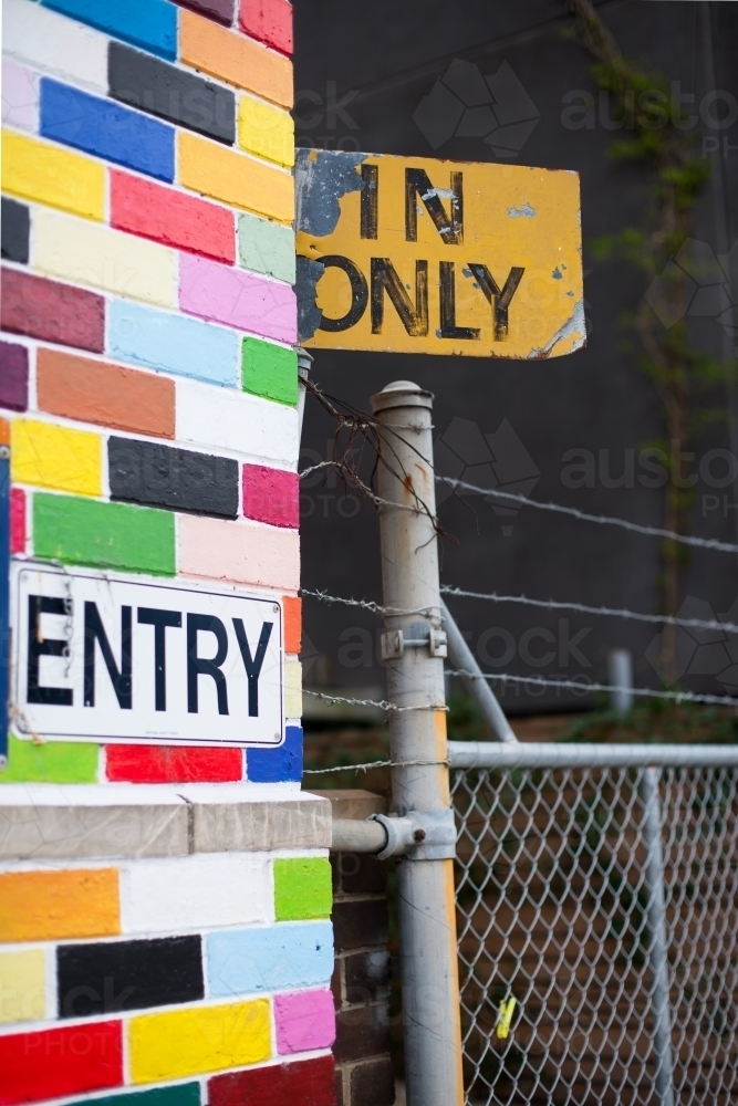 Image of Coloured brick wall, signage and gate Austockphoto