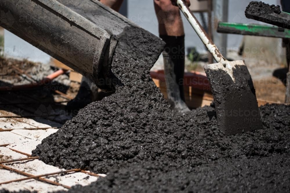 Coloured cement concrete pouring out of chute - Australian Stock Image