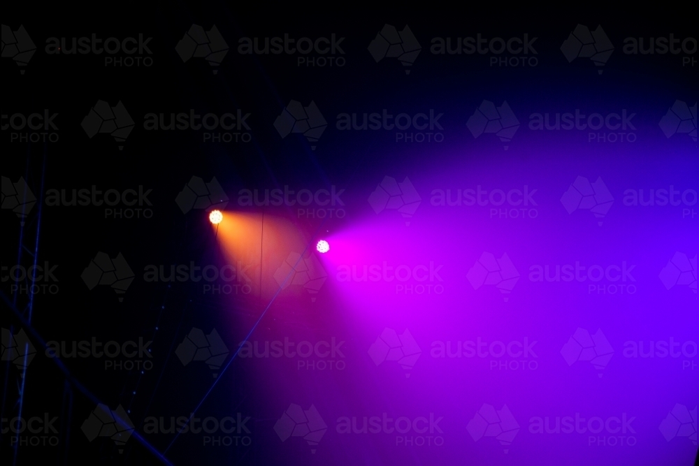 Coloured circus lights inside dark tent - Australian Stock Image