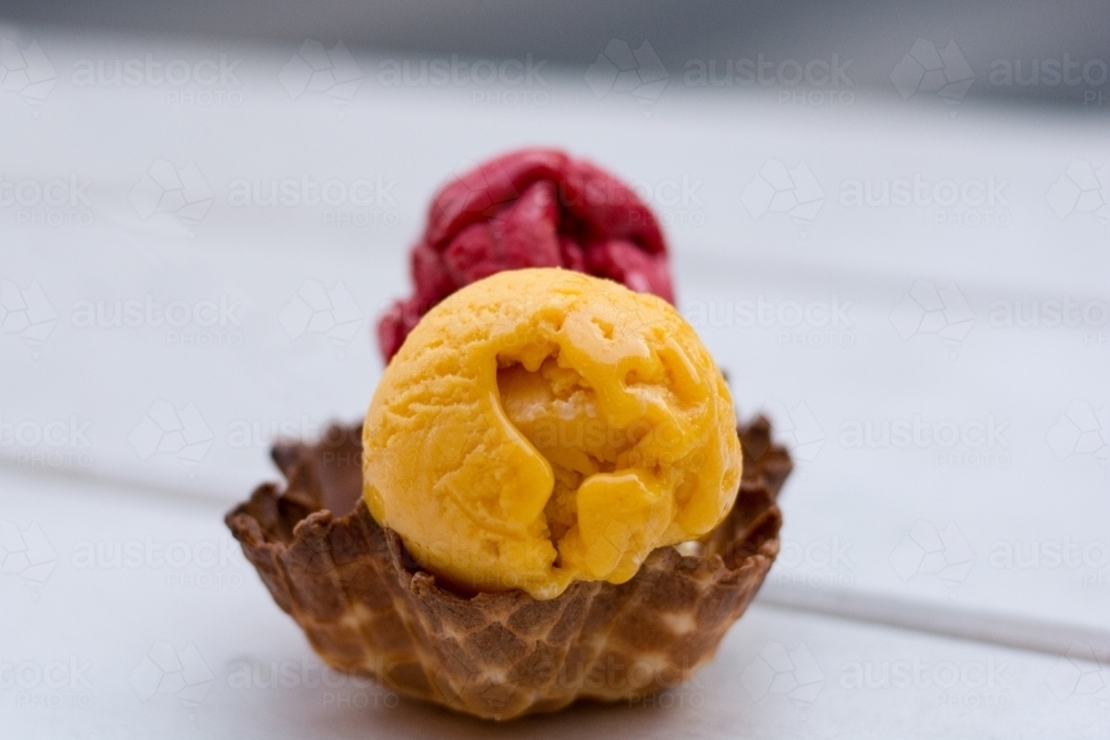 Coloured scoops of ice-cream in an ice cream cup - Australian Stock Image