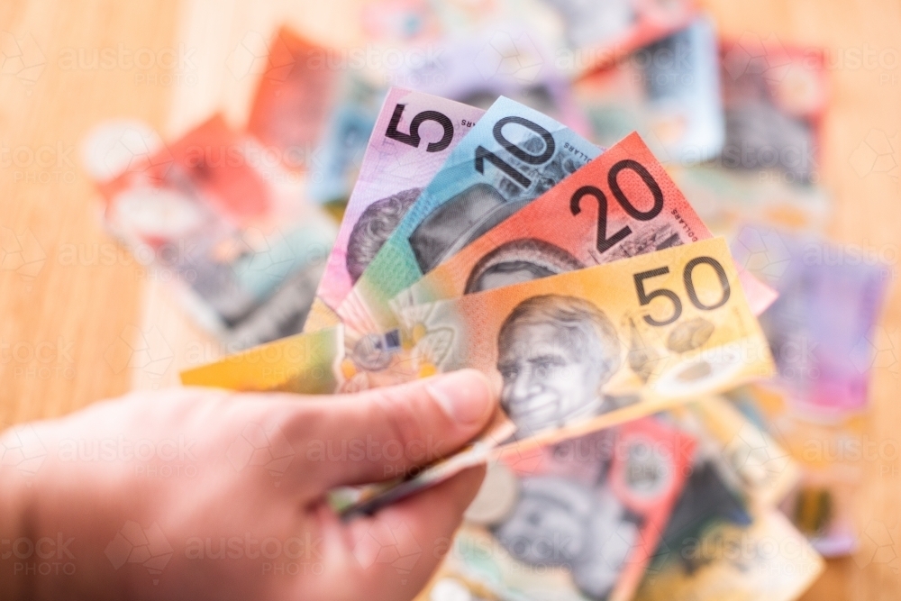 colourful Australian money in a fan with more money in the background - Australian Stock Image
