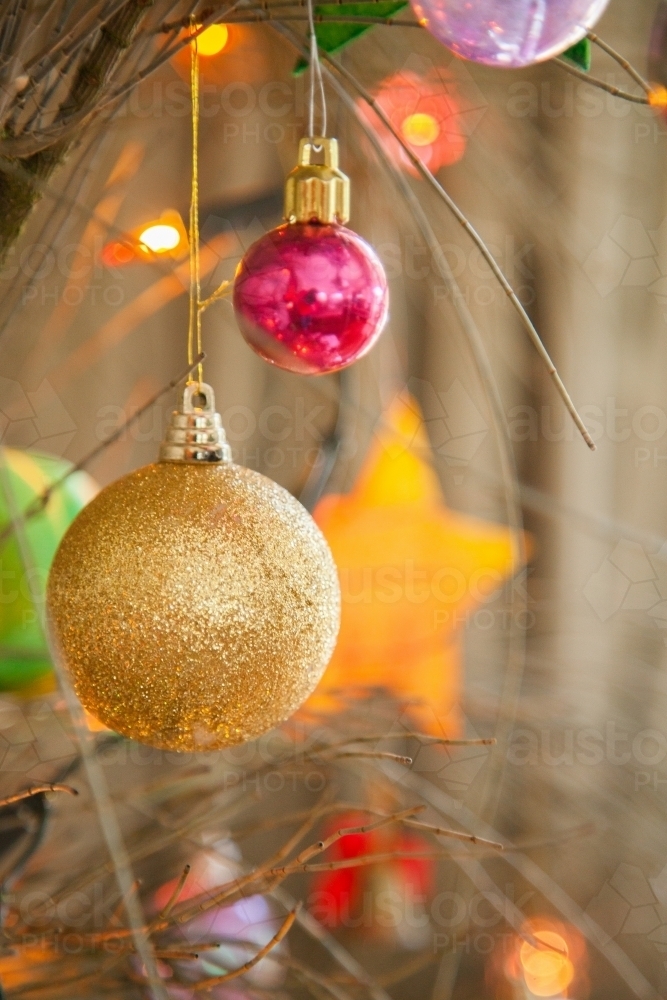 Image of Colourful Christmas baubles hanging on tree Austockphoto