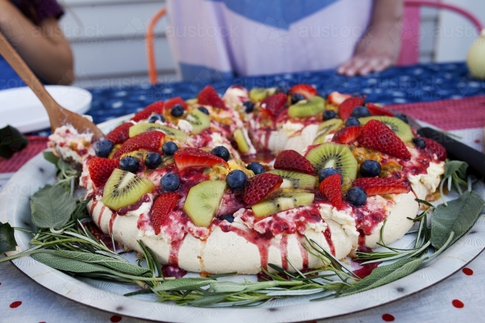 Colourful Christmas pavlova on table being served - Australian Stock Image