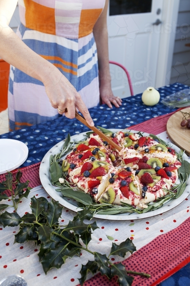 Colourful Christmas pavlova on table being served out - Australian Stock Image