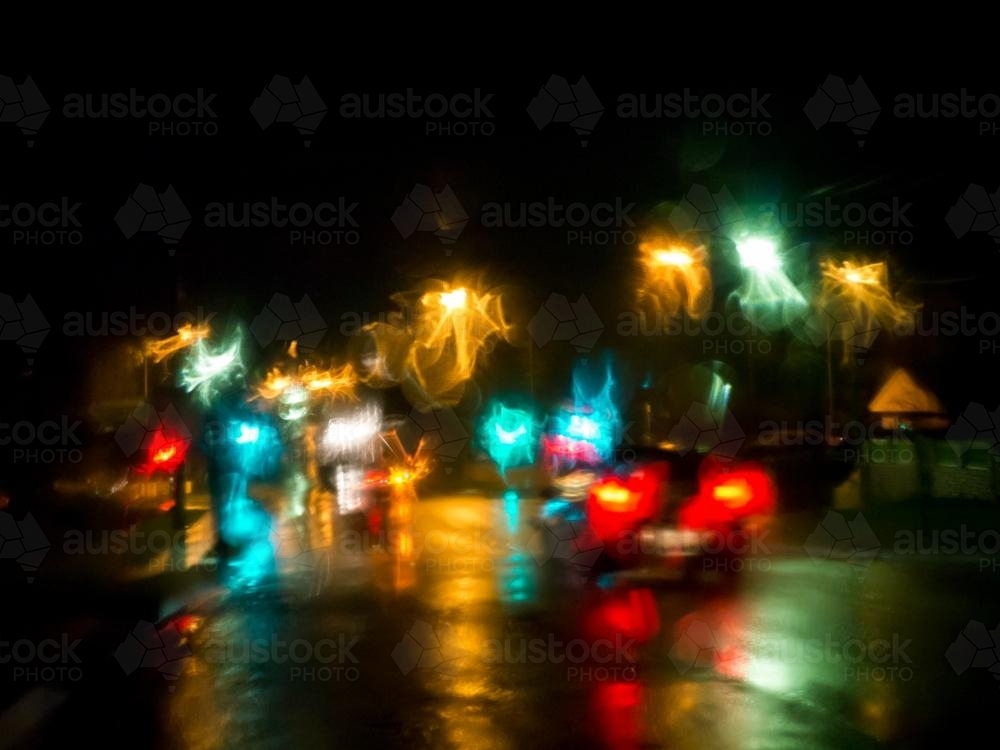 Colourful city light patterns distorted by rain on a car windscreen - Australian Stock Image