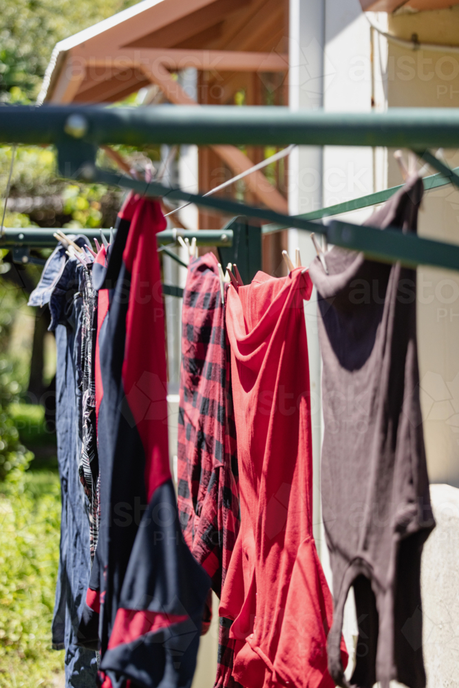 Colourful clothes drying on a sunny backyard line - Australian Stock Image