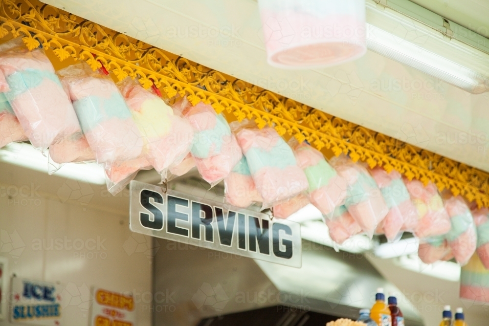 Colourful fairy floss hanging above serving sign in sideshow alley - Australian Stock Image