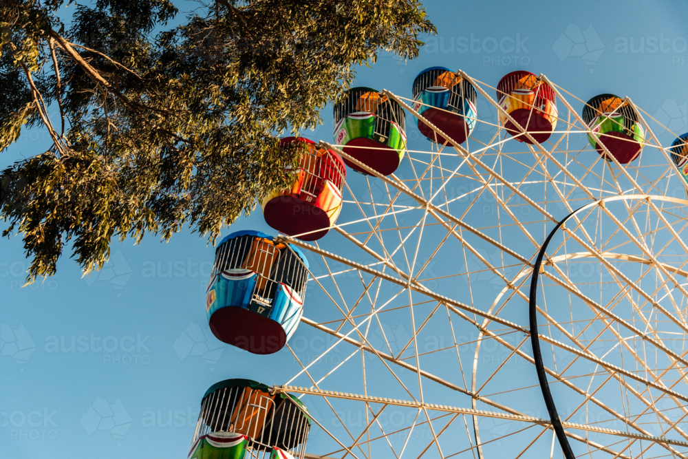 Colourful Ferris Wheel Ride Against a Blue Sky in the Afternoon Sun - Australian Stock Image