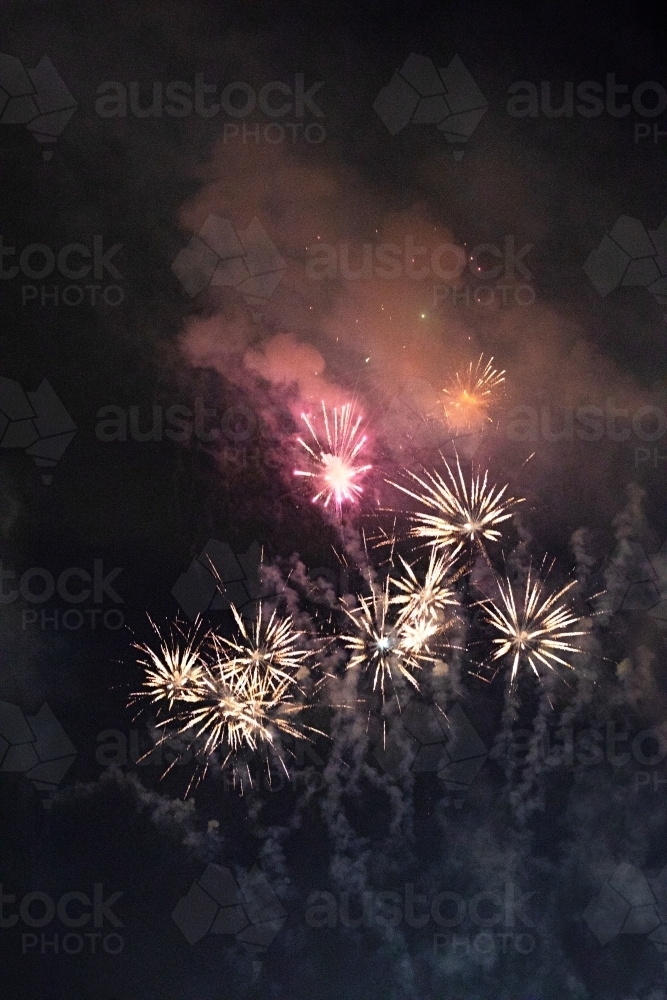 Colourful fireworks display in sky at night - Australian Stock Image