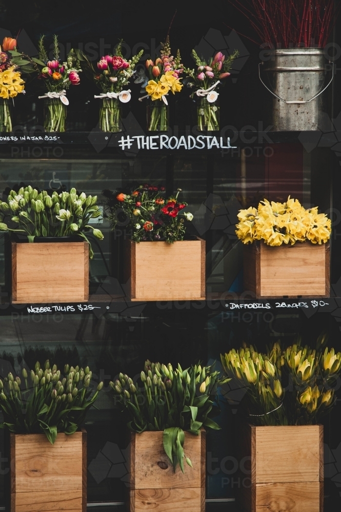 colourful flowers displayed in wooden boxes on a stand - Australian Stock Image
