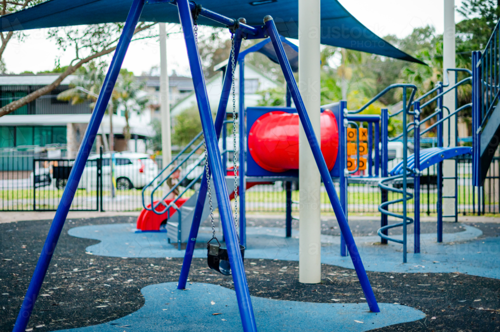 Colourful kids playground surrounded by trees - Australian Stock Image