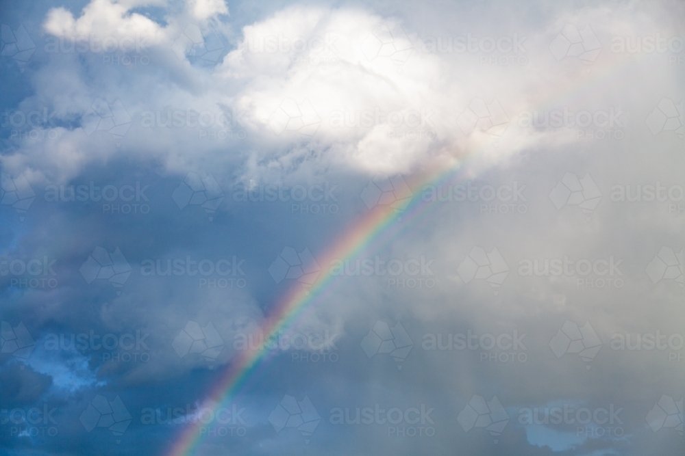 colourful rainbow disappearing into the clouds showing sky only - Australian Stock Image