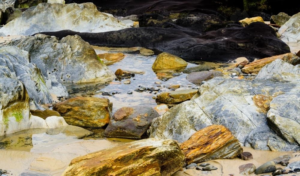Colourful rocks and corals around a rock pool - Australian Stock Image
