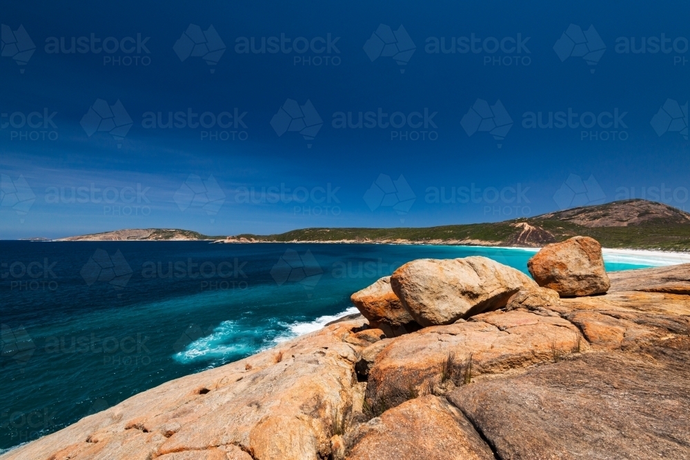 Colourful rocky foreground with sweeping view of Southern Ocean coastline - Australian Stock Image