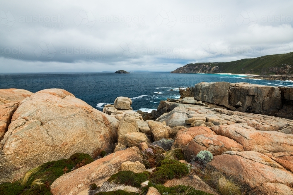 Colourful rocky foreshore on Southern Ocean with stormy sky - Australian Stock Image