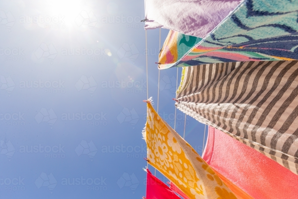 Colourful towels and swimmers hanging on washing line - Australian Stock Image
