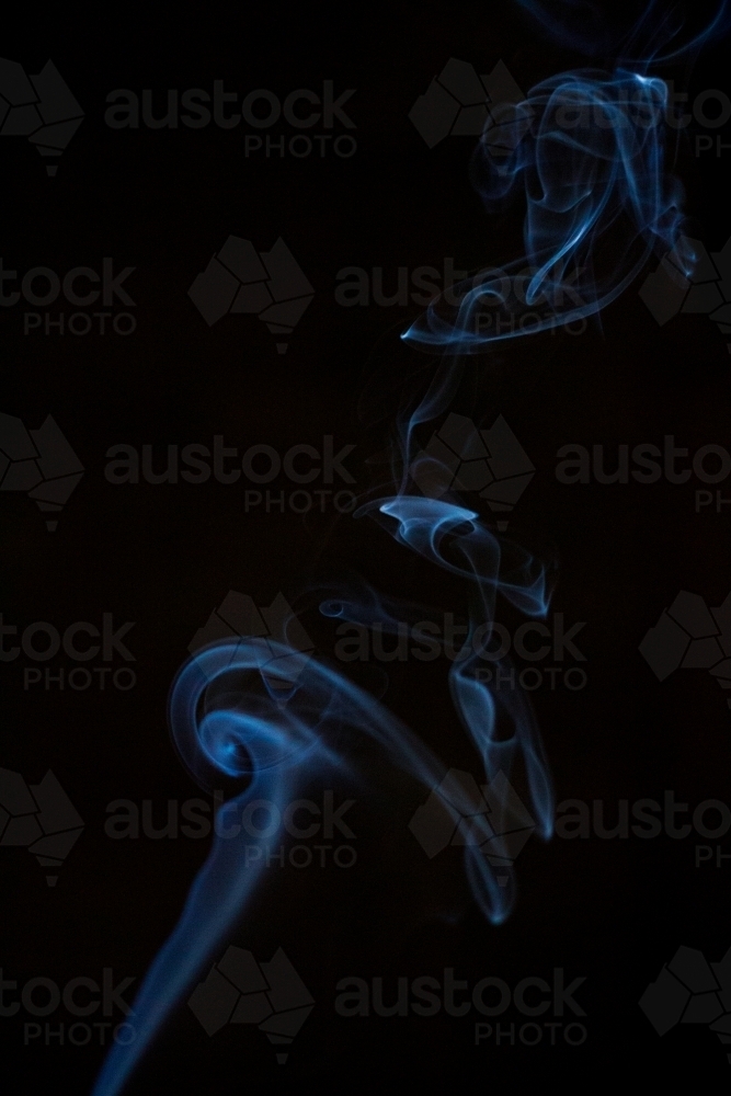 Column of fine smoke in darkness - Australian Stock Image
