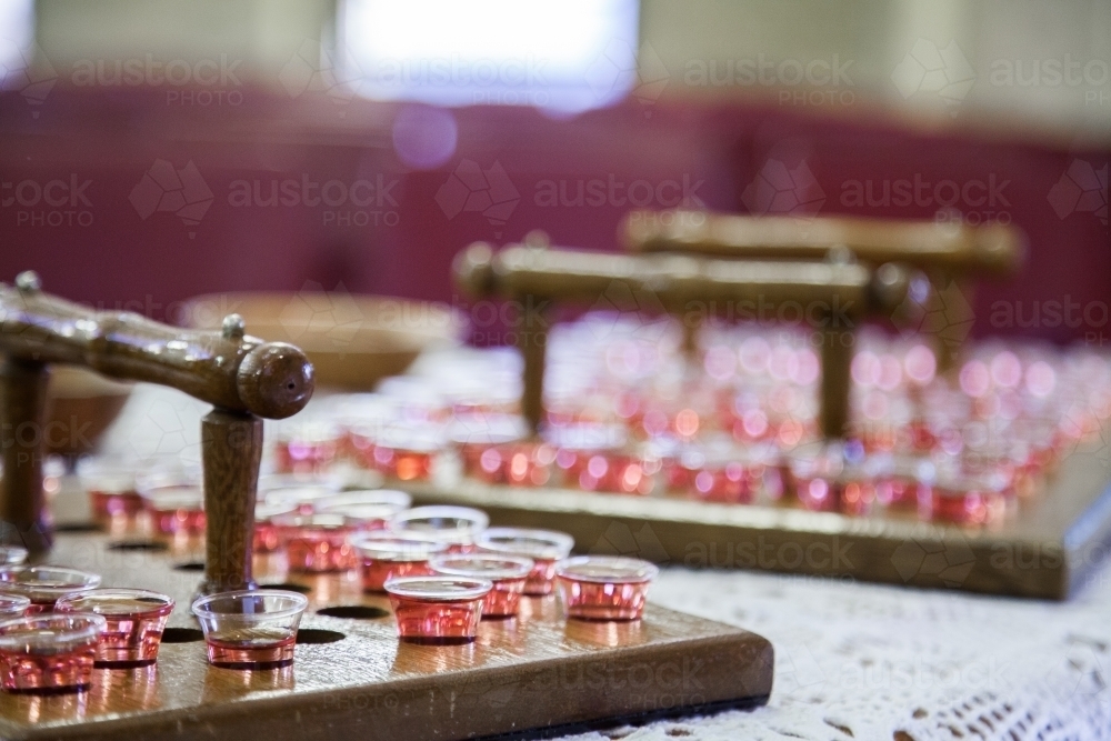 Communion cups of juice in trays and bread for a church service - Australian Stock Image