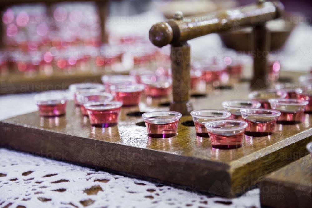 Image of Communion cups of juice in trays and bread for a church