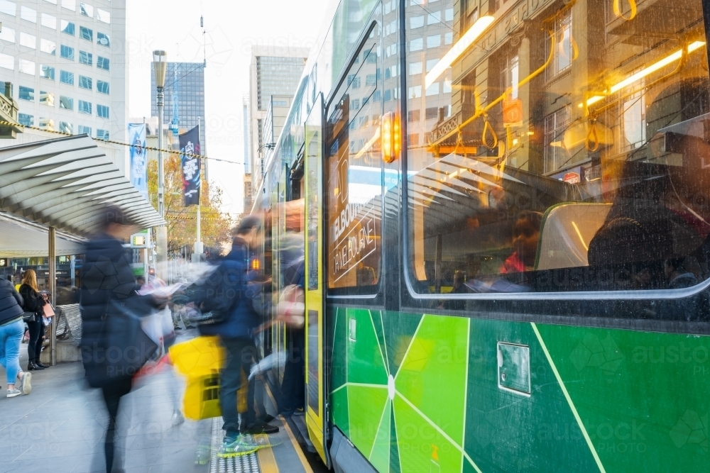 Commuters rushing to board public transport in a city street - Australian Stock Image