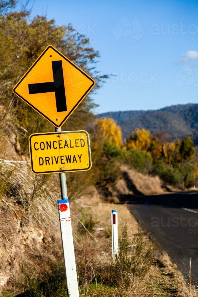 Concealed driveway sign beside road - Australian Stock Image