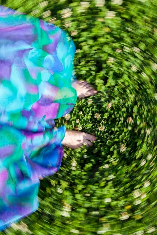 Concept - vertigo, imbalance, dizziness. Spinning photo of bare feet standing on clover lawn - Australian Stock Image