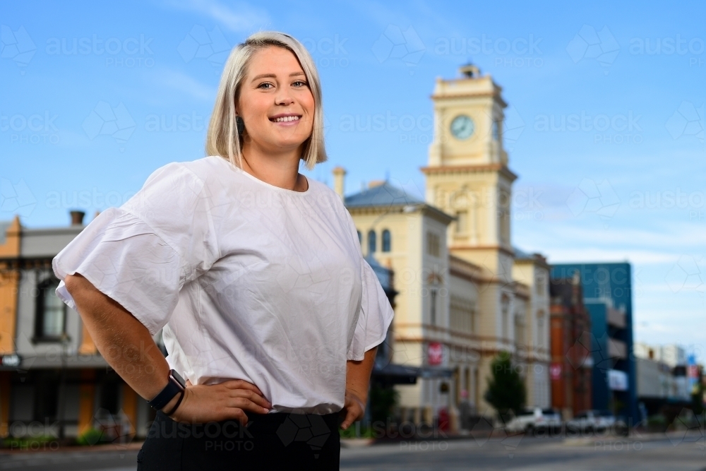Confident young caucasian woman in main street of rural town - Australian Stock Image