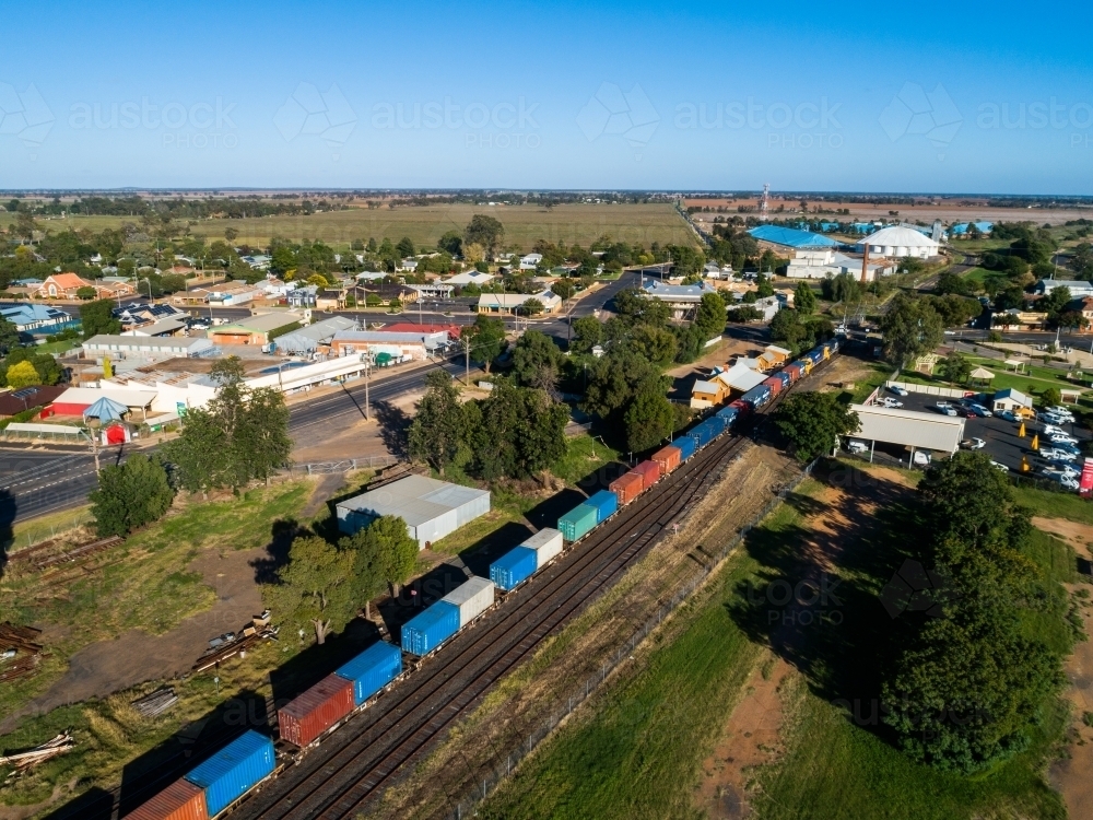 Containers on a freight train in small Aussie town on bright sunlit morning - Australian Stock Image