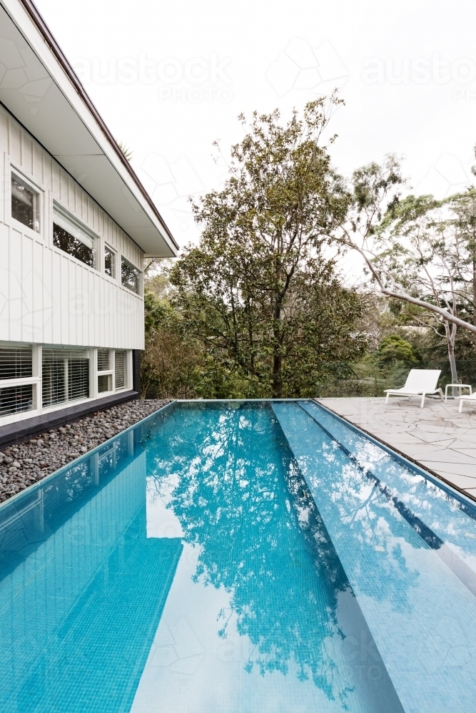Contemporary fully tiled swimming pool in mid century modern Australian home - Australian Stock Image