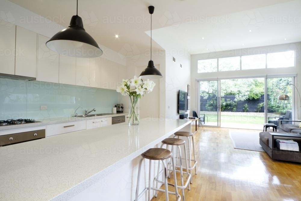 Contemporary kitchen and living room with bar stools - Australian Stock Image