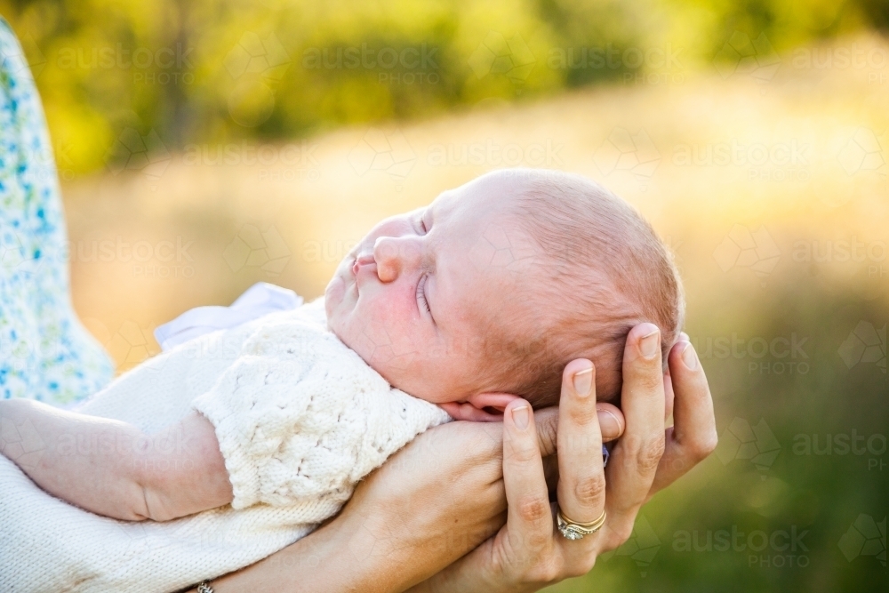 Image of Content sleepy baby in mothers arms Austockphoto